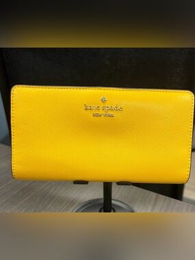 Kate Spade Madison Large Slim Bi-fold Wallet in the color Daffodil